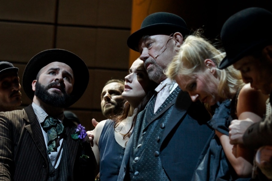 Ralf Rachbauer als Harry in »My Fair Lady« an der Oper Köln: in einer Figurengruppe mit Hüten und Mänteln