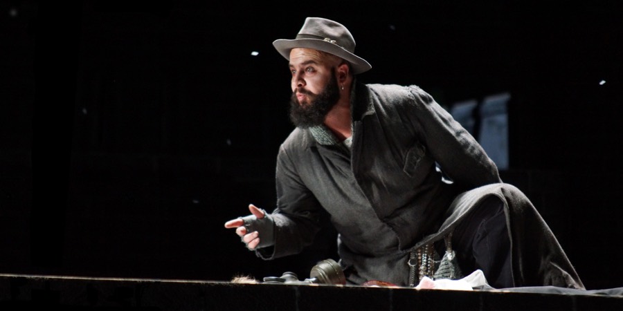Ralf Rachbauer als Mastro Trabucco in »La Forza del Destino« an der Oper Köln: am Bühnenrand kniend im Seitenlicht
